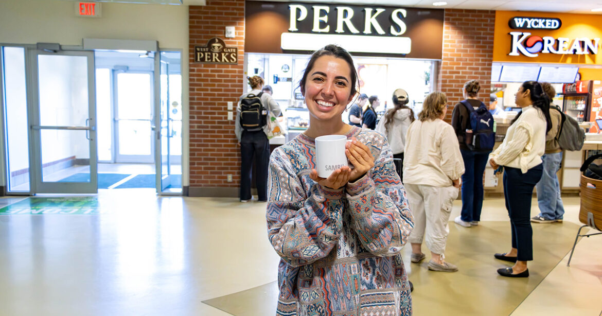 Alexandra Daignault standing in front of the campus coffee shop her social enterprise supplies